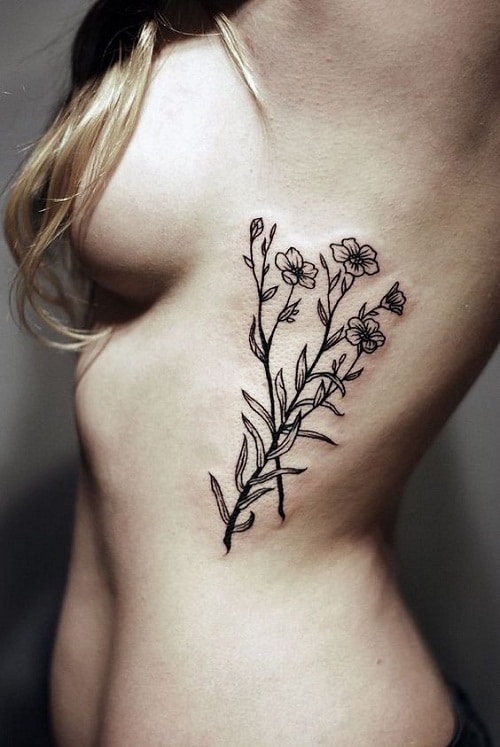 Fine line flower tattoo on the side boob.
