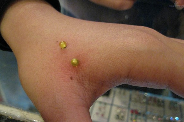 Yellow Barbell Hand Piercing