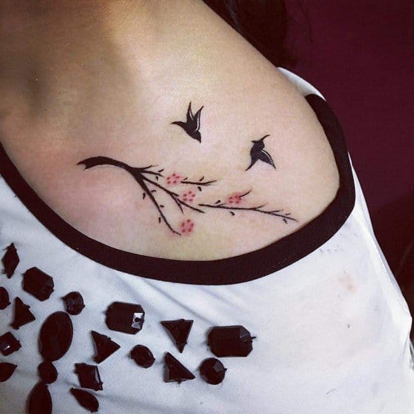 Flying birds tattoo located on the collarbone.